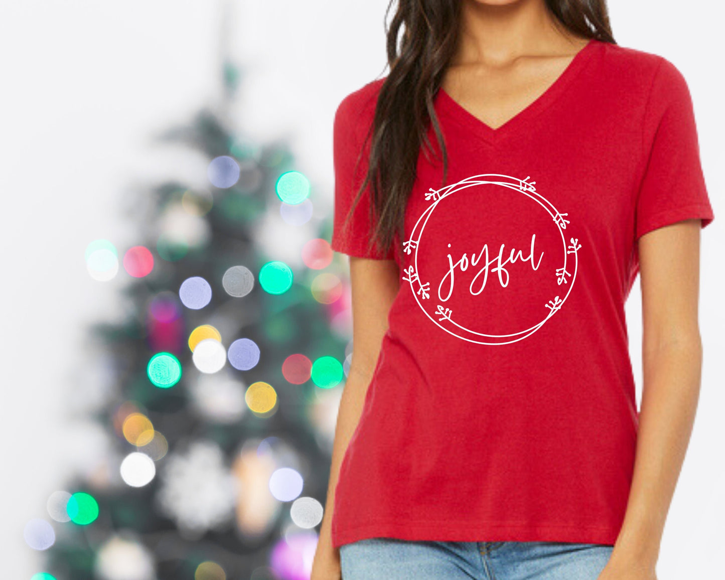 Woman wearing red v-neck shirt with the word "joyful" surrounded by a holiday wreath
