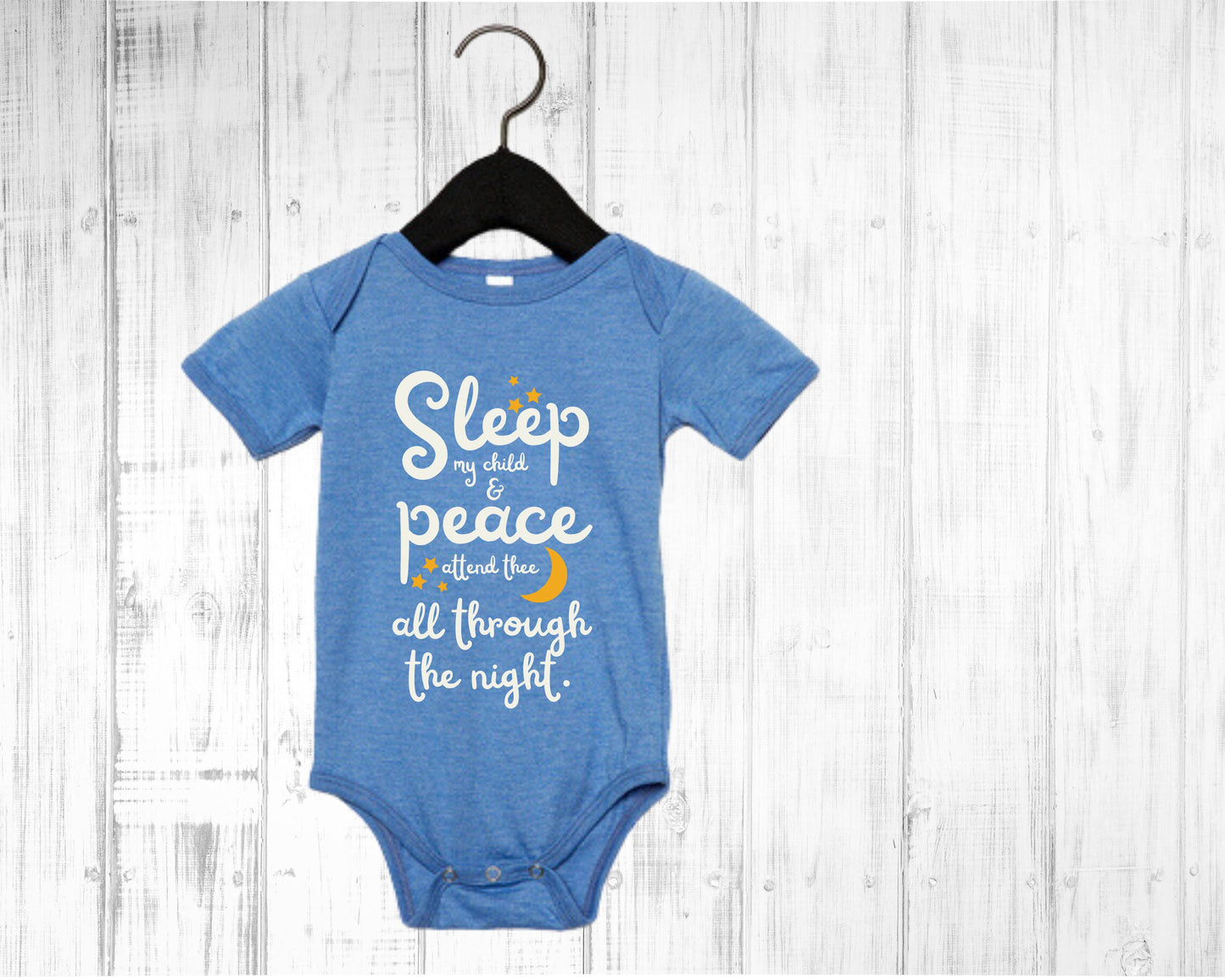 Blue baby onesie with white lettering with the words from the lullaby, "Sleep my child and peace attend thee all through the night." Stars and moon in gold.