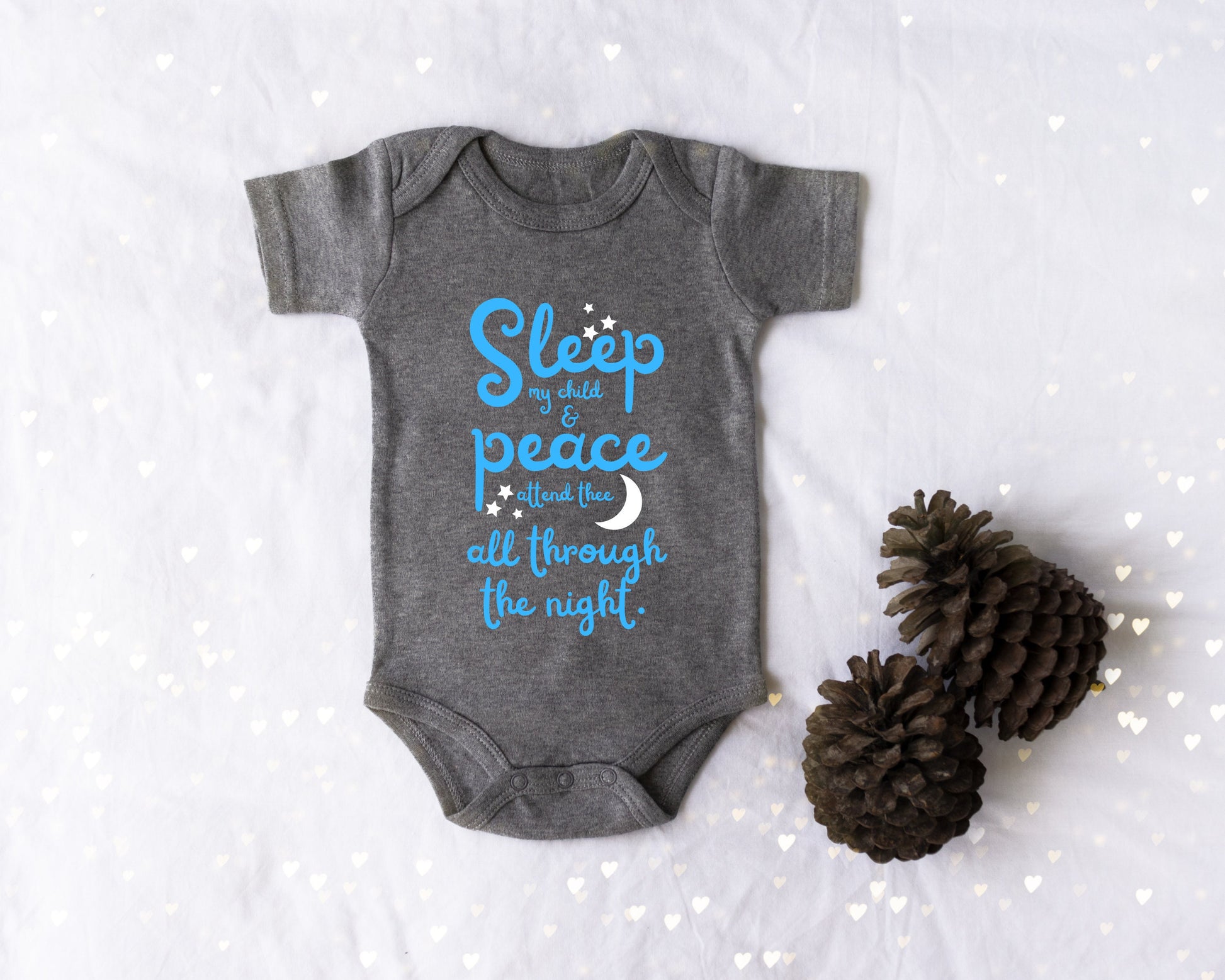 Gray baby onesie with blue lettering with the words from the lullaby, "Sleep my child and peace attend thee all through the night." Stars and moon in white.